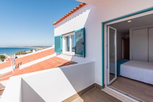 a balcony with a bed and a view of the ocean at Prainha Luxury Apartment in Alvor