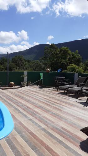 a deck with chairs and a table and a fence at Vyzuh in Vale do Capao