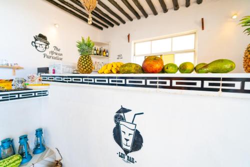 a counter with fruits and vegetables on shelves at The African Paradise Beach Hotel in Bwejuu