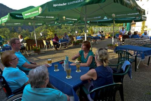 un gruppo di persone seduti a un tavolo con bevande di Landgasthof-Pension Ochsen a Forbach