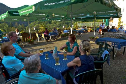 eine Gruppe von Menschen, die mit Getränken am Tisch sitzen in der Unterkunft Landgasthof-Pension Ochsen in Forbach