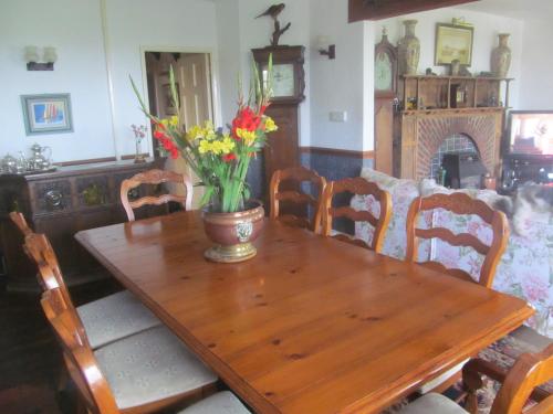 une table en bois avec un vase de fleurs. dans l'établissement Upton Cross B&B, à Bude