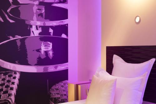 a bedroom with a bed and a purple wall at Hôtel Brésil Opéra SPA in Paris
