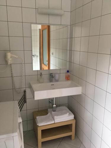 a bathroom with a sink and a mirror and towels at Gábriel Apartman in Kőszeg
