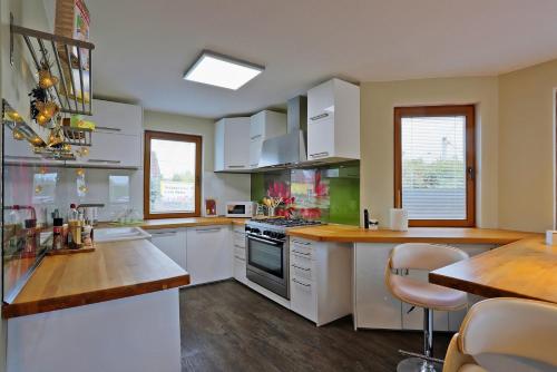 una cucina con armadi bianchi e ripiano in legno di ELTAKO penzion a Karlovy Vary