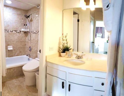 a bathroom with a sink and a toilet and a mirror at Waikiki Kuhio 1-bedrm Apt, Ocean view, Free Parking & Wifi in Honolulu