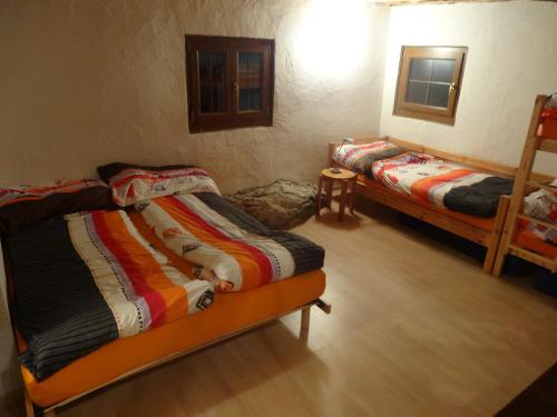 two beds in a room with wooden floors at Chalet Edelweiss in Hérémence