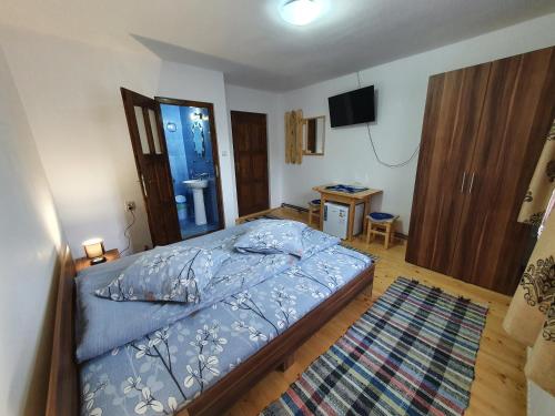 a bedroom with a bed and a television in it at Casa Cerbu in Arieşeni