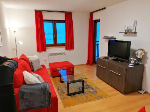 a living room with a red couch and a tv at Apartment Kupres in Kupres
