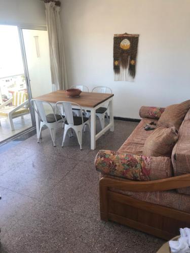 sala de estar con mesa y sofá en Piriapolis apartamento en Piriápolis
