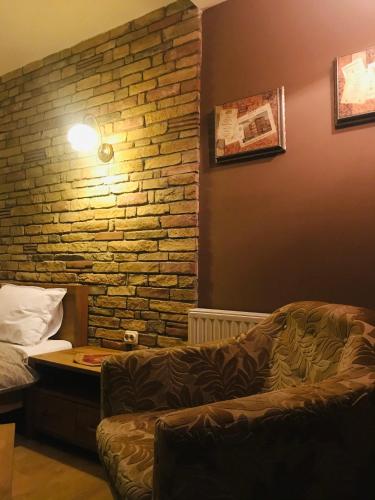 a living room with a couch and a brick wall at VNVP Amber in Štip