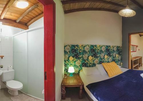 a bedroom with a blue bed and a toilet at Pousada Waikiki in Praia do Rosa