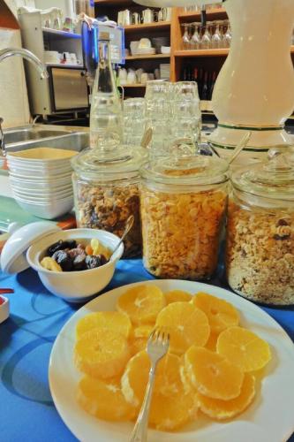 a table with a plate of fruit and jars of food at Hotel Kriemhilde in Worms