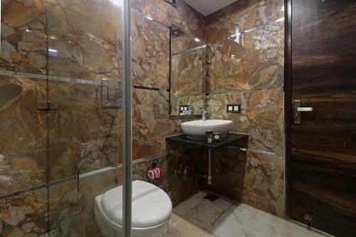 a bathroom with a toilet and a sink and a shower at Hotel Mannat international by Mannat in New Delhi