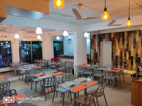 a restaurant with tables and chairs in a room at Laguna Beach Hotel & Resort in Cox's Bazar