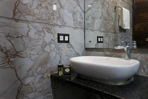 a bathroom with a sink and a marble wall at Hotel Mannat international by Mannat in New Delhi