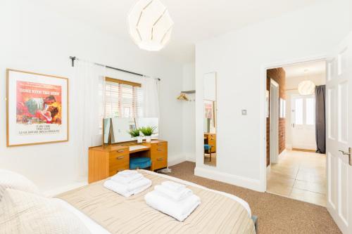 a white bedroom with a bed and a desk at Grundy's Lane Apartments in Malvern Wells