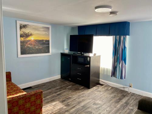 a room with a tv and a couch and a window at Days Inn by Wyndham Lincoln in Lincoln