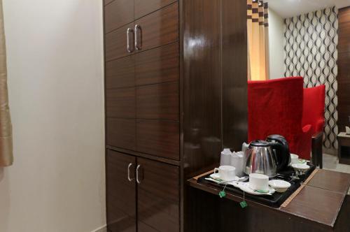 cocina con armarios de madera y mesa con tetera en Hotel Mannat international by Mannat, en Nueva Delhi