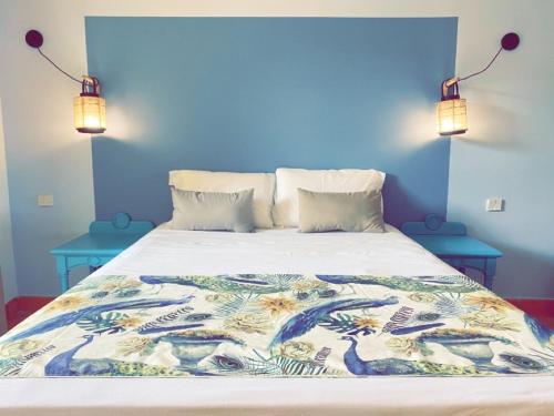 een blauwe slaapkamer met een bed met een blauwe muur bij Résidence de la baie 2 - BLEU SOLEIL TARTANE in La Trinité