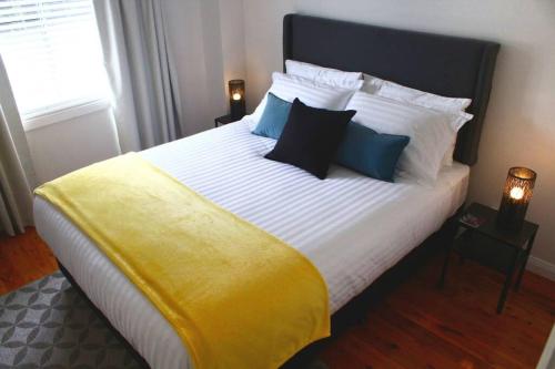 1 dormitorio con 1 cama grande con manta amarilla en Ascot Road - discover Bowral, en Bowral