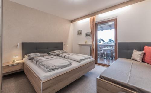 - une chambre avec un grand lit et une fenêtre dans l'établissement Ferienwohnungen Haus Christine, à Rifiano