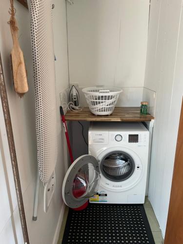 a washing machine in a laundry room with a shelf at Jetty's End Bicheno in Bicheno