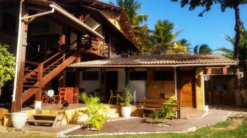 a house on the beach with palm trees at Vila Bello Pontal in Coruripe