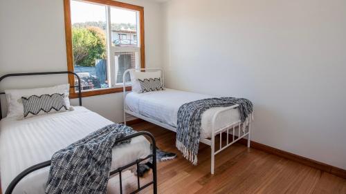 a room with two twin beds and a window at Jetty's End Bicheno in Bicheno