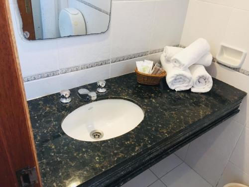 a bathroom with a sink and towels on a counter at San Remo Terrazas Hotel in Piriápolis