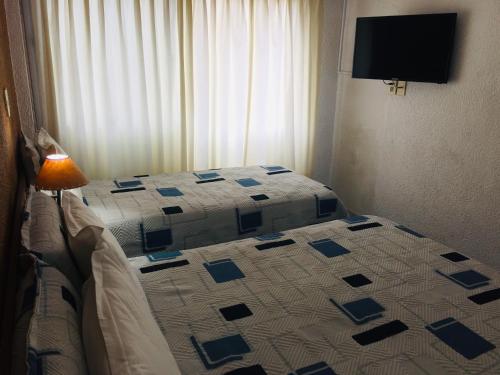 a bedroom with a bed with a blue and white quilt at San Remo Terrazas Hotel in Piriápolis