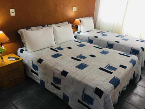 a hotel room with two beds with blue and white sheets at San Remo Terrazas Hotel in Piriápolis