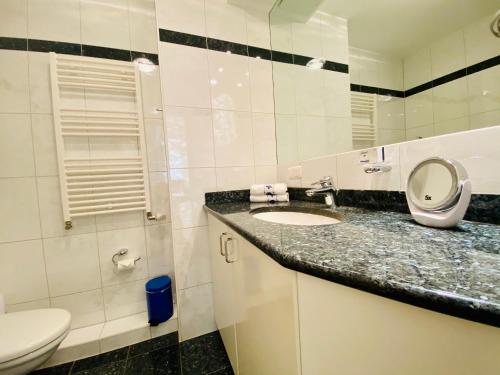 a bathroom with a sink and a toilet and a mirror at Residenz Bleichröder - Ferienwohnung 27 in Heringsdorf