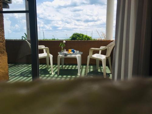 a table and two chairs on a balcony with a view at San Remo Terrazas Hotel in Piriápolis