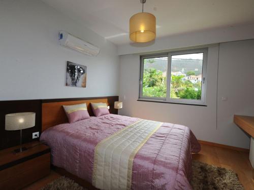 - une chambre avec un grand lit et une fenêtre dans l'établissement Blue Villa, à Arco da Calheta