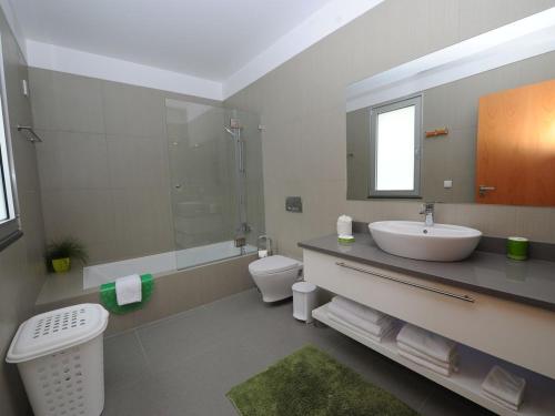 La salle de bains est pourvue d'un lavabo, de toilettes et d'un miroir. dans l'établissement Blue Villa, à Arco da Calheta