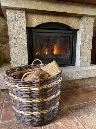 a fireplace with a basket in front of it at Casa de Costoia in Santiago de Compostela