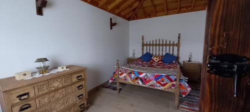 Santa BárbaraにあるCasa da Bisa - Santa Maria - Açoresのベッドルーム(木製ベッド1台、ドレッサー付)