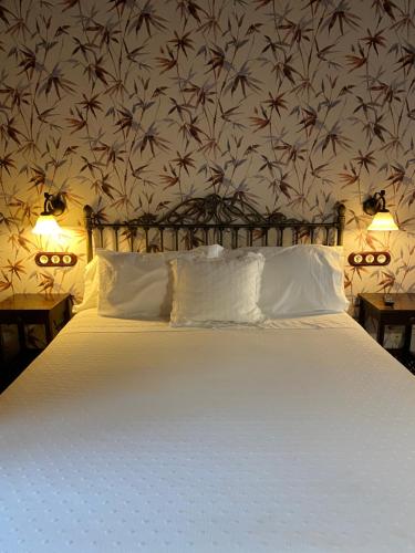 a bedroom with a large white bed with a floral wallpaper at Casa de Costoia in Santiago de Compostela