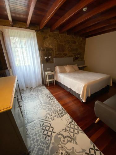 a bedroom with a bed and a table in a room at Casa de Costoia in Santiago de Compostela