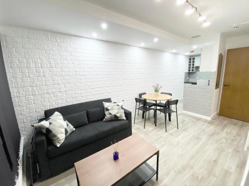 a living room with a couch and a table at The Works - Private one bedroom apartment in Manchester