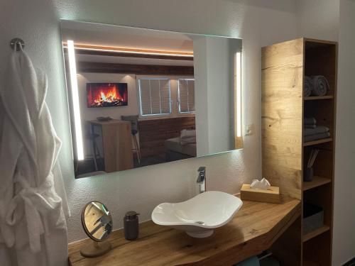 bagno con lavandino e specchio di Mountainsuite a Oberwald