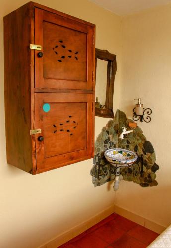 a bathroom with a wooden cabinet and a sink at Casa Encuentro Ecolodge, Outdoor Gym and Yoga in Guatapé