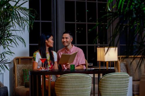 a man and woman sitting at a table with a laptop at The Don CeSar in St Pete Beach