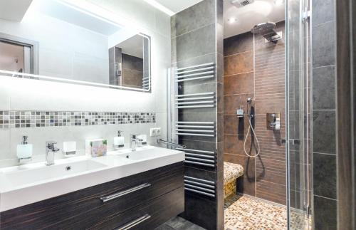 a bathroom with a sink and a shower at Villapark Luxury Apartman Balatonfüred in Balatonfüred