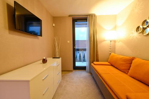 a living room with a couch and a tv at Villapark Luxury Apartman Balatonfüred in Balatonfüred