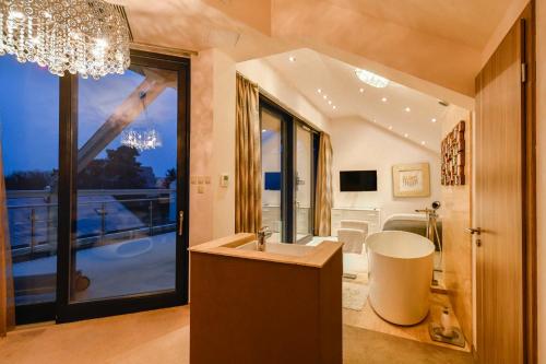 a bathroom with a sink and a large window at Villapark Luxury Apartman Balatonfüred in Balatonfüred