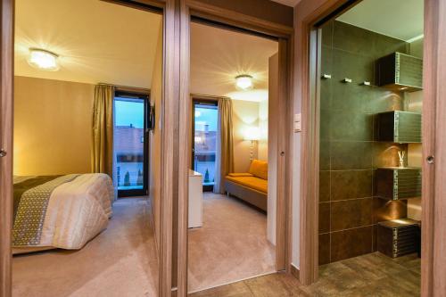 une chambre d'hôtel avec un lit et une porte en verre dans l'établissement Villapark Luxury Apartman Balatonfüred, à Balatonfüred