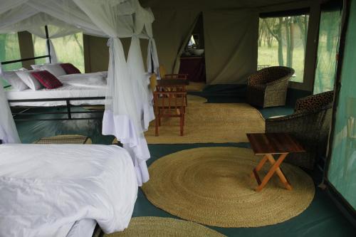 a bedroom with a tent with a bed and a table at Osero Serengeti Luxury Tented Camp in Banagi