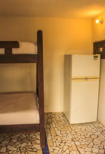 a room with a bunk bed and a refrigerator at Casa Encuentro Ecolodge, Outdoor Gym and Yoga in Guatapé